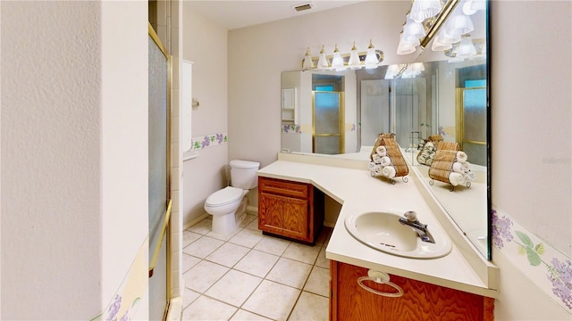 bathroom featuring tile patterned flooring, vanity, a shower with door, and toilet