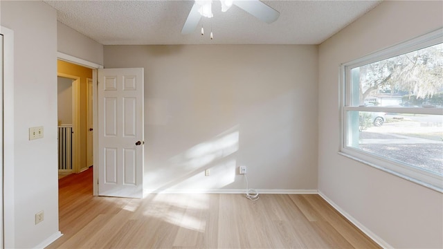 empty room featuring ceiling fan, a textured ceiling, and light hardwood / wood-style flooring