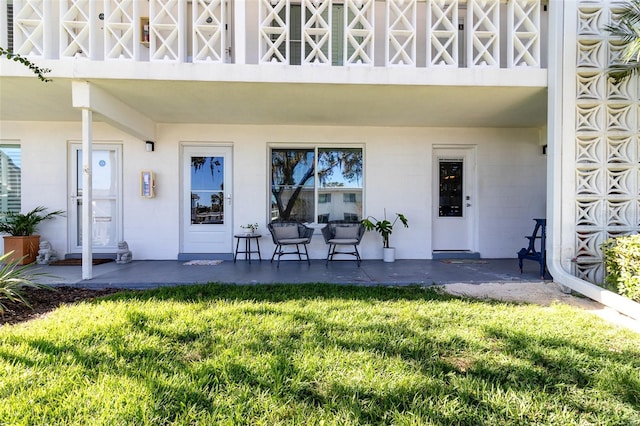 entrance to property with a balcony and a yard