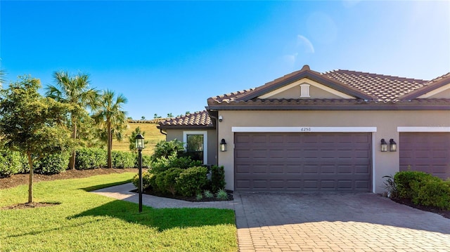 mediterranean / spanish-style home featuring a garage and a front lawn