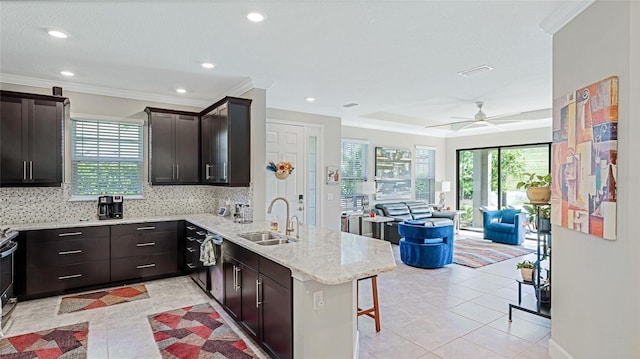 kitchen with a breakfast bar, a healthy amount of sunlight, kitchen peninsula, and sink