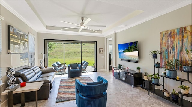 living room with light tile patterned floors, a raised ceiling, and ceiling fan