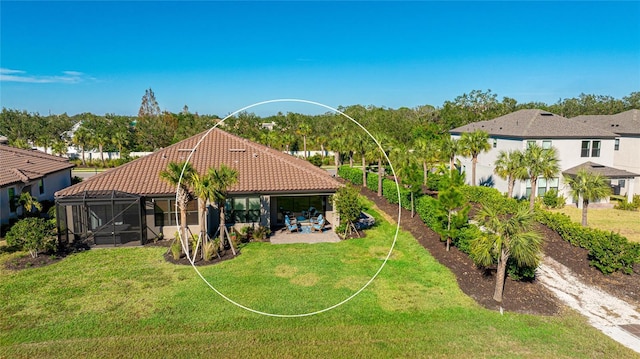 rear view of house featuring a lanai, a yard, and a patio