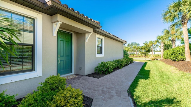 entrance to property with a lawn