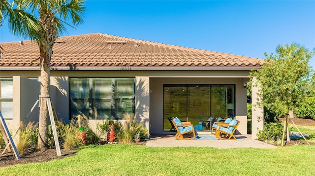 rear view of house with a patio area and a lawn