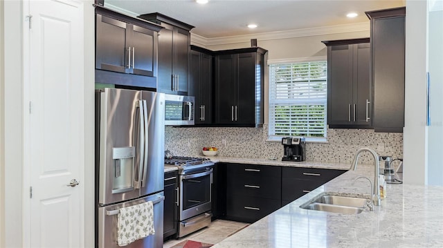 kitchen featuring sink, crown molding, decorative backsplash, light stone countertops, and stainless steel appliances