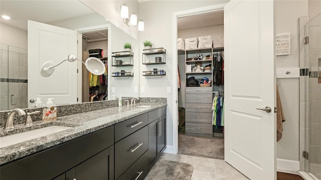 bathroom featuring tile patterned floors, vanity, and walk in shower