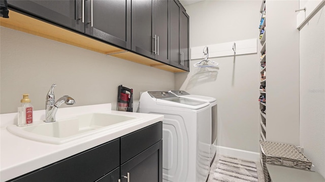 washroom featuring sink, cabinets, and independent washer and dryer