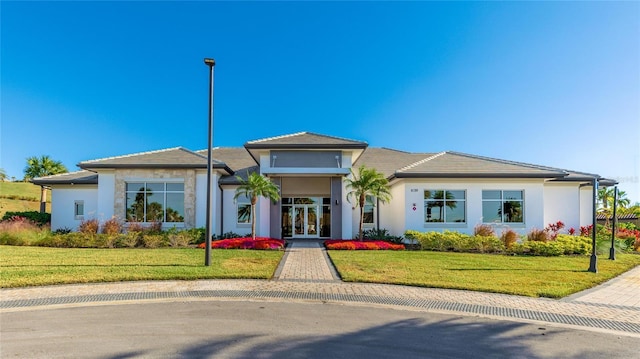 view of front of home with french doors and a front lawn