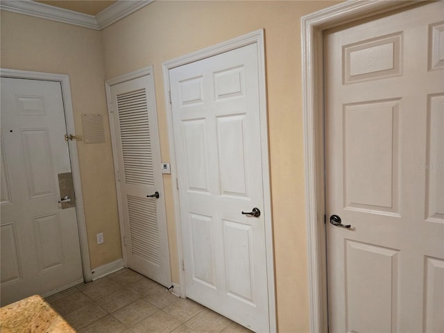 hall featuring light tile patterned floors and crown molding