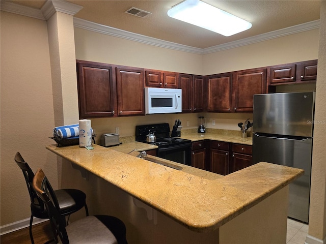 kitchen featuring black range with electric cooktop, kitchen peninsula, stainless steel fridge, crown molding, and a breakfast bar area