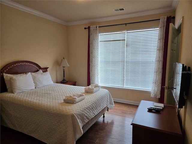 bedroom featuring multiple windows, ornamental molding, and hardwood / wood-style flooring