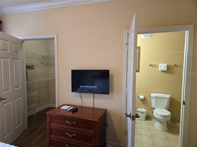 bathroom with crown molding, tile patterned flooring, and toilet