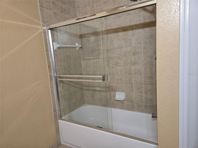 bathroom featuring shower / bath combination with glass door