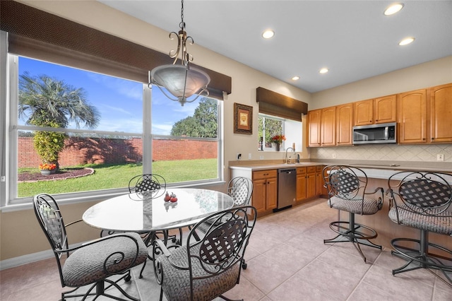 kitchen with appliances with stainless steel finishes, backsplash, a wealth of natural light, and sink