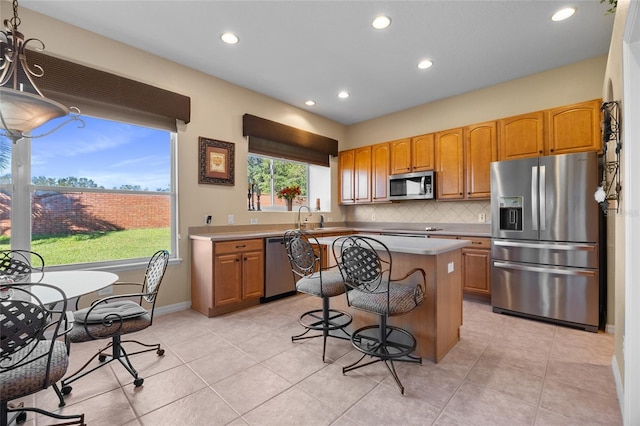 kitchen with a center island, light tile patterned floors, sink, and appliances with stainless steel finishes