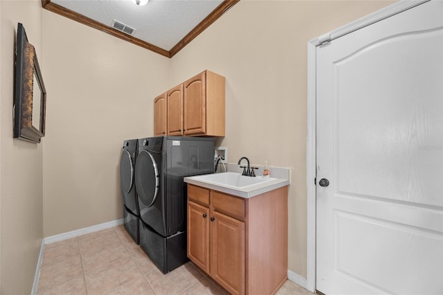 laundry area with cabinets, crown molding, sink, light tile patterned floors, and washing machine and clothes dryer