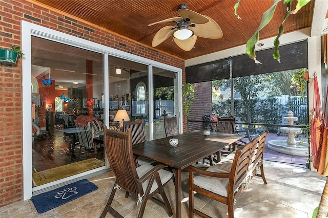 sunroom / solarium with a ceiling fan and wooden ceiling