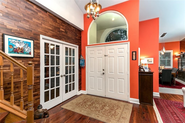 entrance foyer with dark wood-style floors, baseboards, a chandelier, and french doors