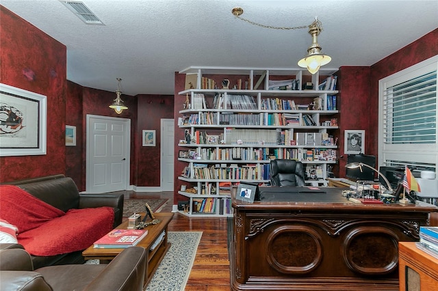 office space with a textured ceiling, dark wood finished floors, and visible vents