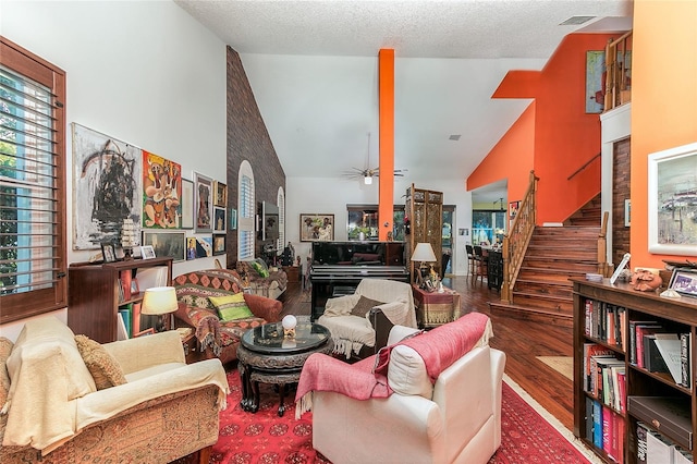 living area featuring visible vents, dark wood-type flooring, stairs, a textured ceiling, and high vaulted ceiling