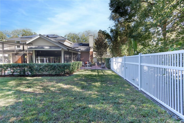 view of yard featuring a sunroom and a fenced backyard