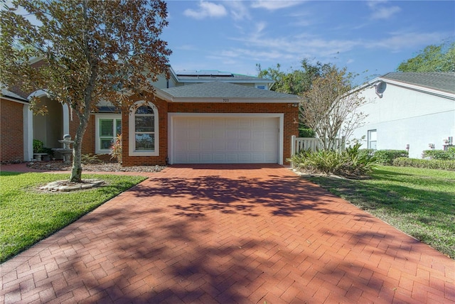 view of front of house with brick siding, decorative driveway, an attached garage, and fence