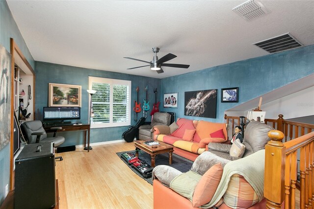 living area featuring ceiling fan, wood finished floors, visible vents, and baseboards