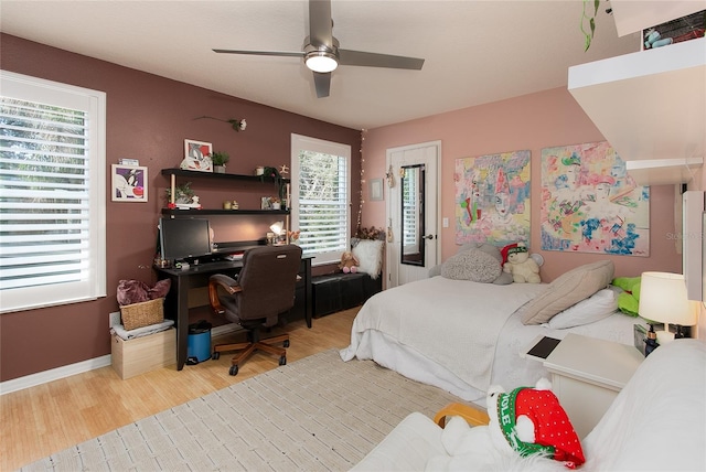 bedroom featuring light wood-type flooring, baseboards, and a ceiling fan