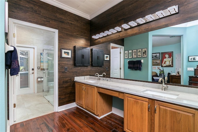 full bath featuring double vanity, a stall shower, hardwood / wood-style flooring, and a sink