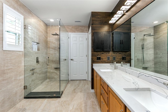 bathroom featuring double vanity, a sink, visible vents, and a shower stall