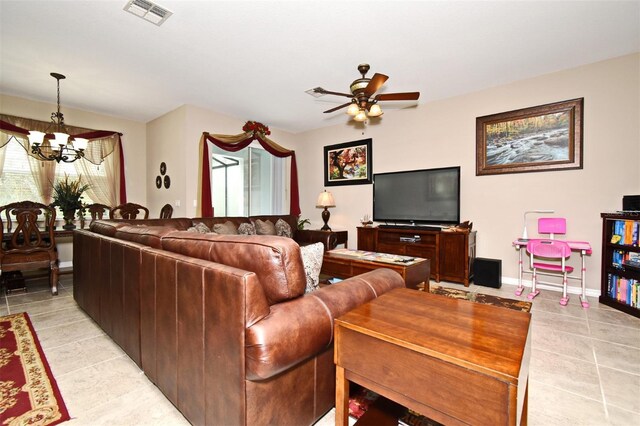 tiled living room featuring ceiling fan with notable chandelier