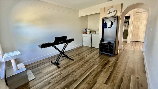 exercise room featuring hardwood / wood-style flooring and washing machine and dryer