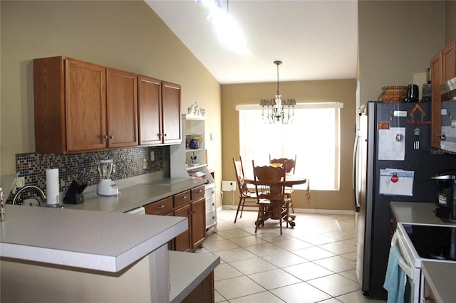 kitchen featuring lofted ceiling, decorative light fixtures, tasteful backsplash, a notable chandelier, and kitchen peninsula