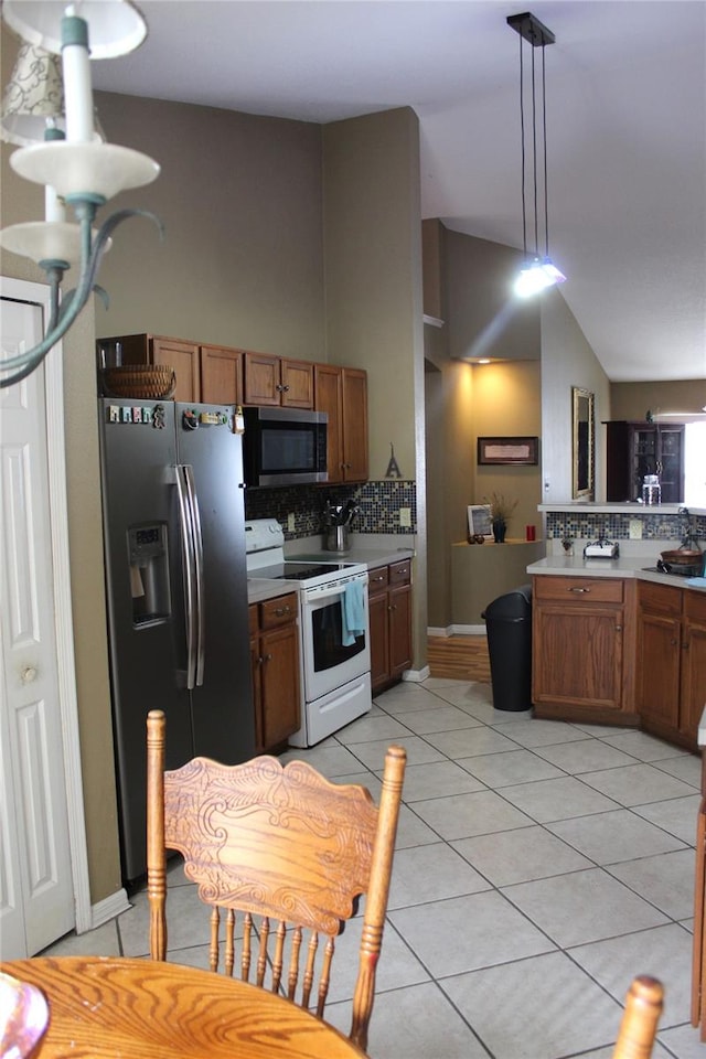 kitchen with backsplash, hanging light fixtures, light tile patterned flooring, and stainless steel appliances