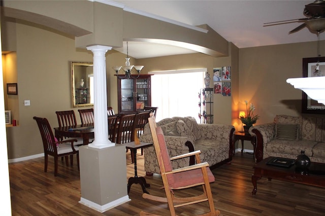 living room with ceiling fan with notable chandelier, ornate columns, and dark wood-type flooring