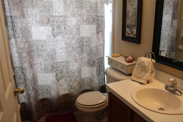 bathroom with curtained shower, vanity, and toilet