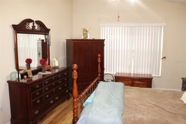 bedroom with light hardwood / wood-style flooring and lofted ceiling