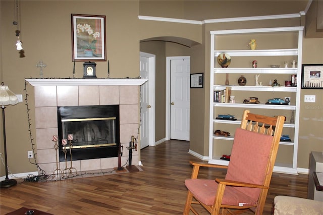 living area with dark hardwood / wood-style floors, crown molding, and a fireplace