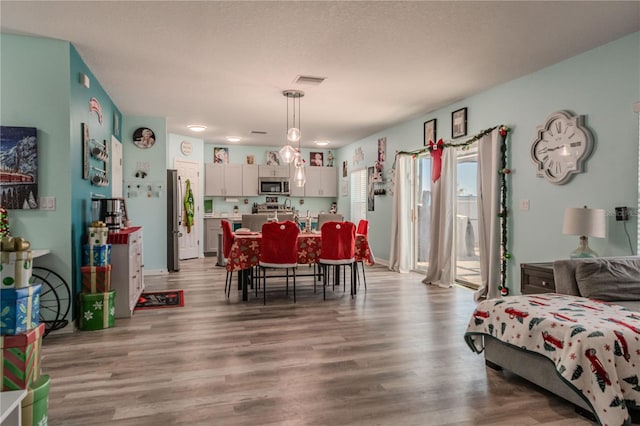 dining space featuring light hardwood / wood-style flooring and a textured ceiling