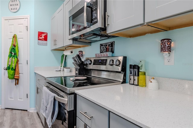 kitchen with white cabinetry, light hardwood / wood-style flooring, and stainless steel appliances