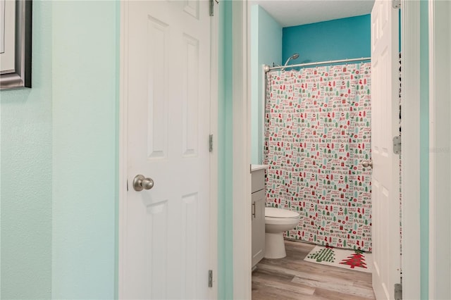 bathroom with wood-type flooring, vanity, toilet, and a shower with curtain