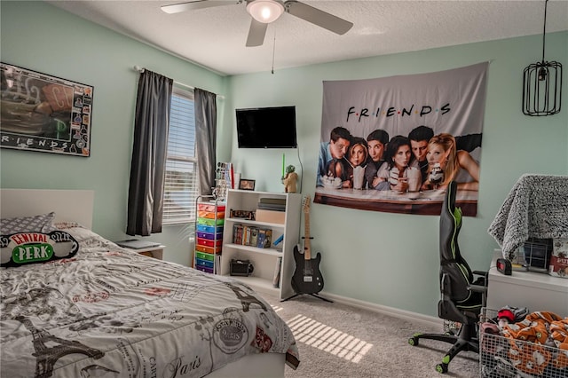 carpeted bedroom with ceiling fan and a textured ceiling