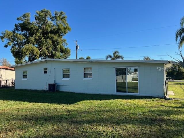 back of property with a yard and central air condition unit