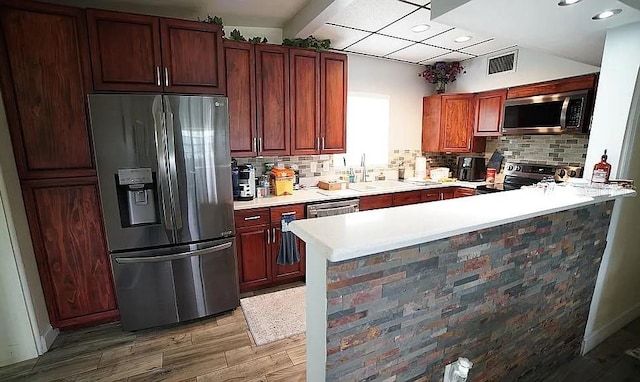 kitchen with decorative backsplash, hardwood / wood-style floors, stainless steel appliances, and sink