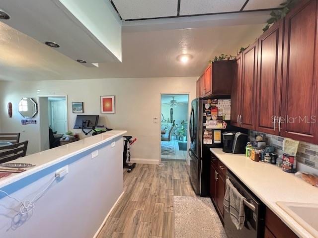 kitchen with tasteful backsplash, sink, light hardwood / wood-style floors, and appliances with stainless steel finishes