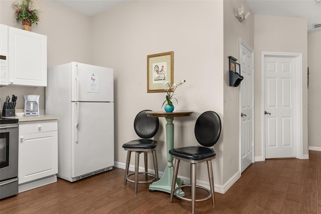 kitchen featuring white cabinets, dark hardwood / wood-style floors, white fridge, and stainless steel electric range