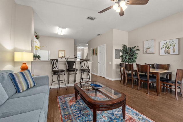 living room featuring electric panel, ceiling fan, and dark hardwood / wood-style flooring