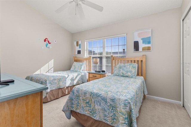 bedroom with ceiling fan, a closet, light colored carpet, and lofted ceiling