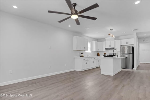 kitchen featuring stainless steel refrigerator, ceiling fan, light hardwood / wood-style floors, a kitchen island with sink, and white cabinets